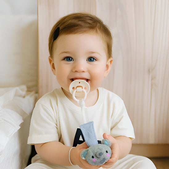 Attache tétine bleue dans les mains d'un bébé dans une chambre. 