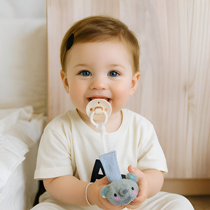 Attache tétine bleue dans les mains d'un bébé dans une chambre. 