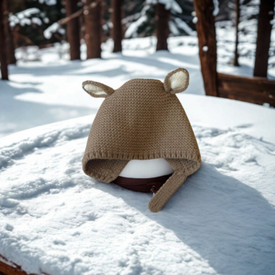 Bonnet bebe kaki TricotDouillet™ sur une table en hiver