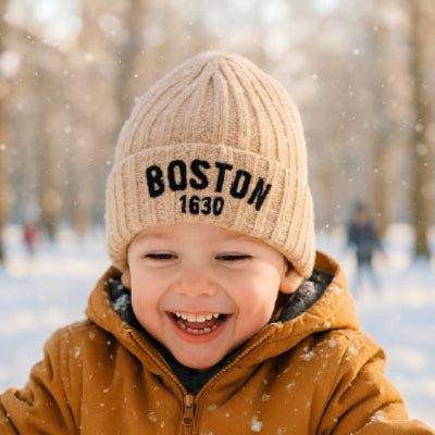 Bonnet bebe kaki boston BostonCool™ sur la tête d'un enfant jouant dehors dans la neige.