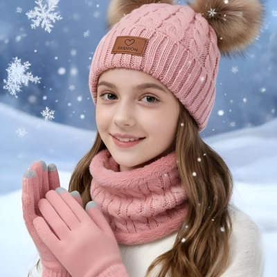Un enfant portant un bonnet tricot rose avec de la neige qui tombe.