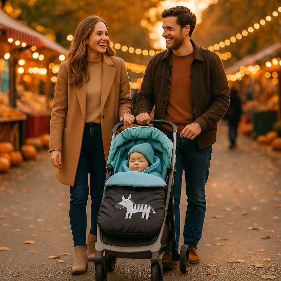 Un papa et une maman marchent dans une rue en automne en poussant un bébé dans une poussette dans une chanceliere bebe bleu.
