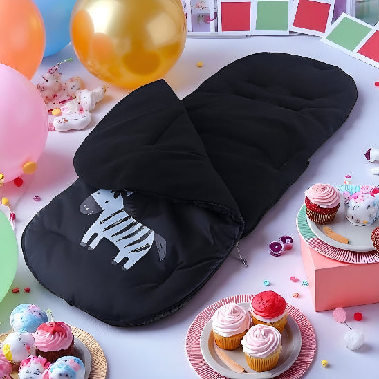 Chanceliere bebe noir avec une image de zèbre sur une table lors d'une fête avec des gâteaux.