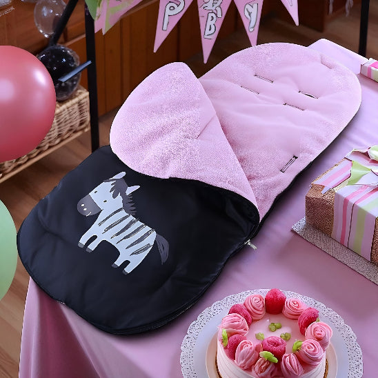 Chanceliere bebe rose avec une image de zèbre sur une table lors d'une fête avec un gâteau et un cadeau.