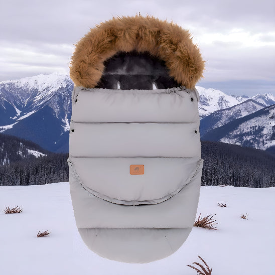 Chanceliere poussette grise sur la neige en montagne.