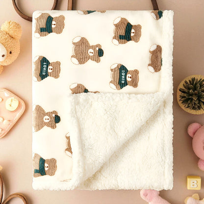 Une couverture blanche avec des oursons, dessus une table rose avec des jouets pour bébé